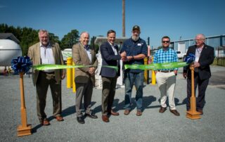 Five gentleman cutting the ribbon on the new fueling station