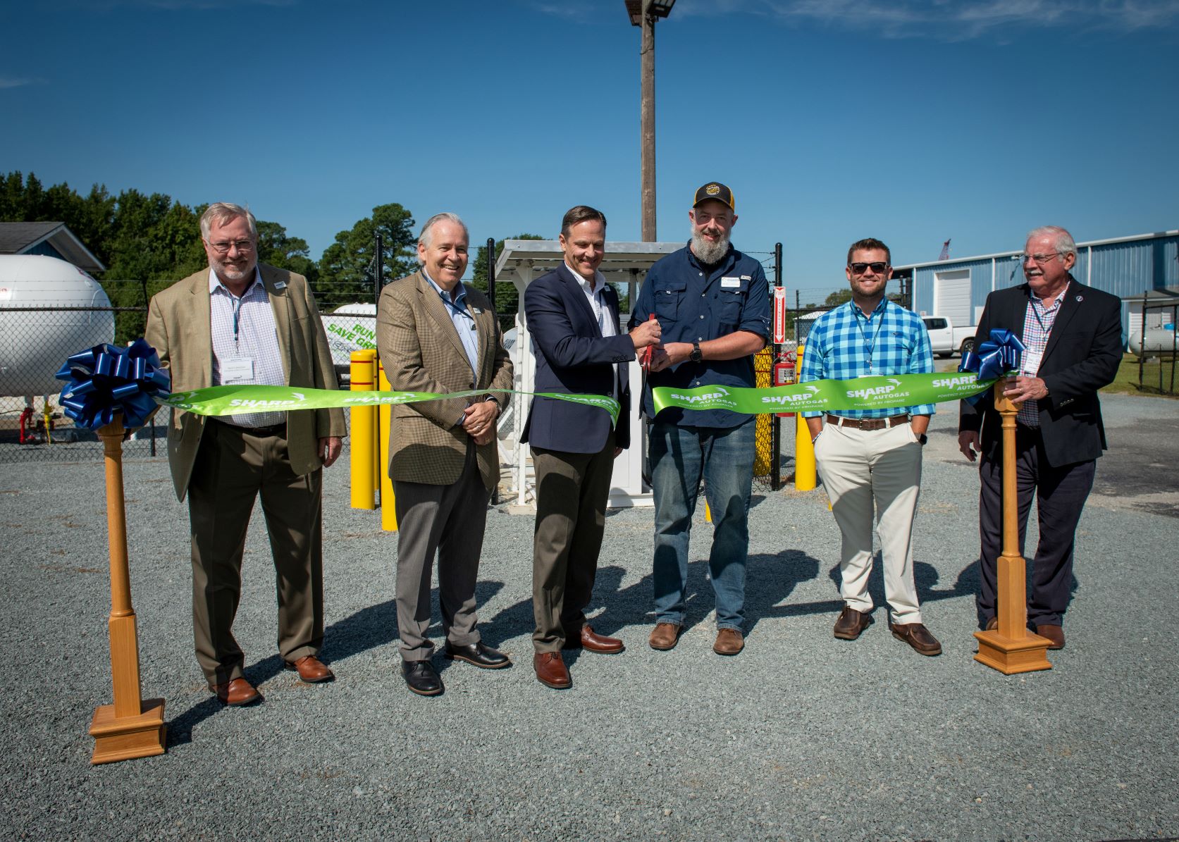 Five gentleman cutting the ribbon on the new fueling station